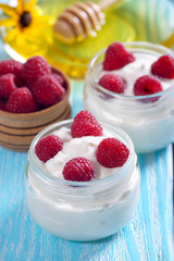 Yogurt with raspberries in a jar on the table.
