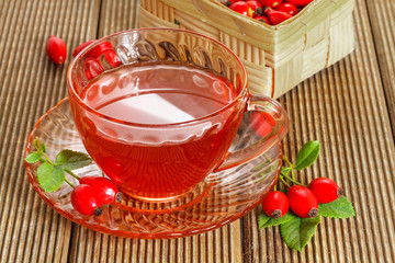 rose hip tea with fresh berries on the wooden background