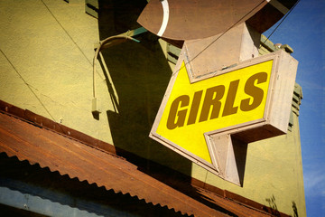 aged and worn vintage photo of girls sign at strip club