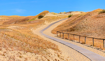 Fototapeta premium Wooden road in the sand dunes. Curonian Spit, Lithuania.
