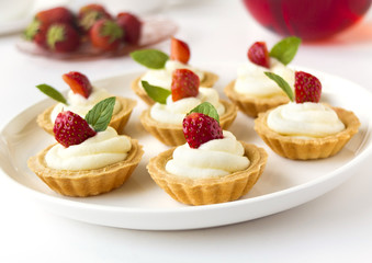 Many cakes, cupcakes with fresh fruits, whipped cream, jelly and mints