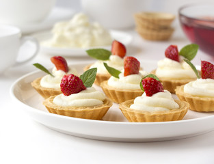 Many cakes, cupcakes with fresh fruits, whipped cream, jelly and mints