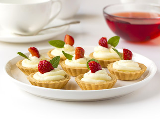 Many cakes, cupcakes with fresh fruits, whipped cream, jelly and mints