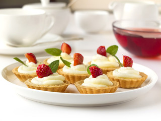 Many cakes, cupcakes with fresh fruits, whipped cream, jelly and mints
