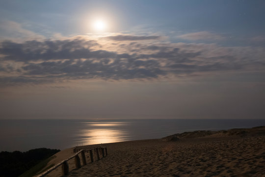 Sandy dunes with moon during nighttime. Baltic coast, Lithuania.