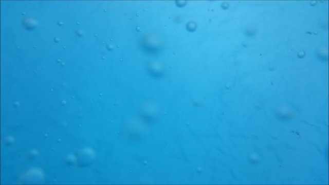 Bubbles underwater in clean blue water floating around