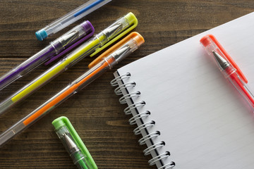 multicolored ballpoint pens and notebook