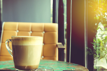 Cup of coffee on wooden table in coffee cafe