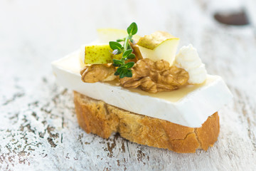 Tapas with brie cheese, pear and walnuts