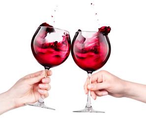 Glasses of red wine with splashes in hand isolated