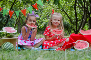 Happy girls eating watermelon having summer picnic