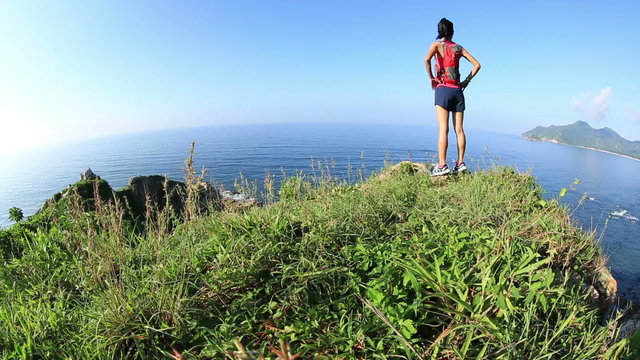 young woman trail runner enjoy the view on beautiful seaside mountain peak 