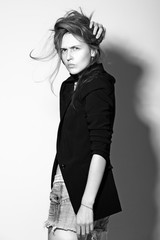 Attractive young woman posing by the wall.