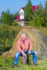 Naklejka na ściany i meble Village man near the haystack