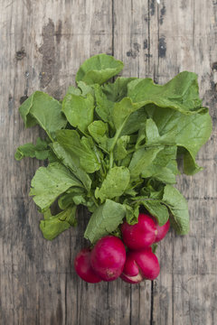bunch of fresh radishes on wooden board