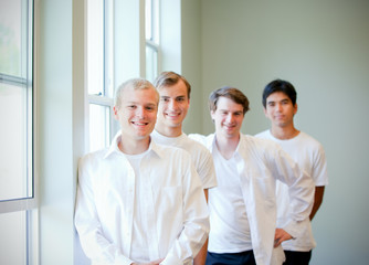 Young groom standing with groomsmen, getting ready for wedding