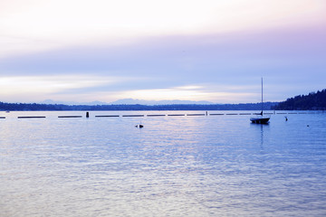 Calm lake waters  at dusk with empty sailboat