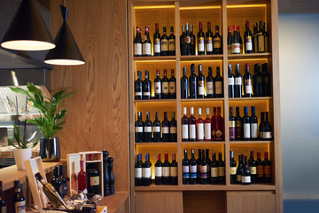 Wine bottles on a wooden shelf.