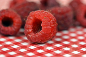 close up of raspberry on checkered plate