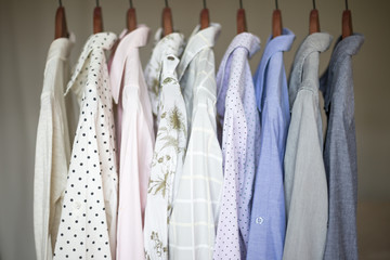 Two piles of warm sweaters for fall or winter on a shelf in a closet