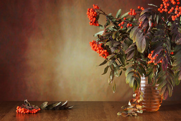 Autumn still life with rowan tree branches in the vase