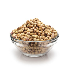 Front view of Organic Dried coriander seeds (Coriandrum sativum) in glass bowl isolated on white background.