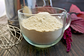 Flour amaranth in glass cup with mixer on board