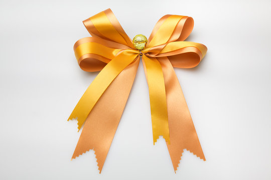 Gold ribbon with bow with tails on white background