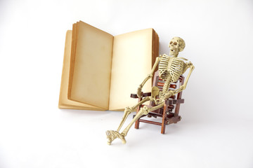 Stock Photo:. Human skeleton Sit on a chair With old books