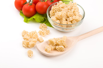 Pasta, tomatoes and pepper on a wooden background