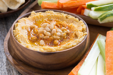 Traditional hummus in bowl with pita bread and vegetables