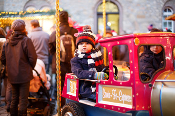 Obraz na płótnie Canvas Little boy on a carousel at Christmas market, outdoors