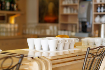 White coffee cups on bar table of a cafe