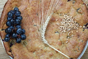Wheat cake with grapes. ears of corn and beans.