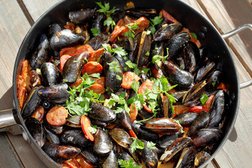 Mussels with chorizo cooking in a pan
