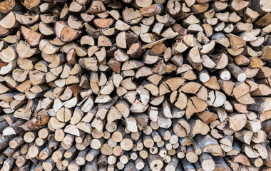 Stack of firewood, wood background texture. Layer of stored cut