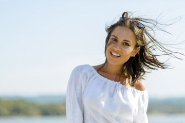 Beautiful young woman posing on a windy summer day