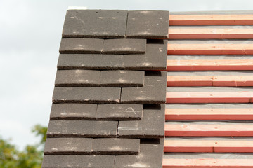 Rows of roof tiles being fitted to wooden battens