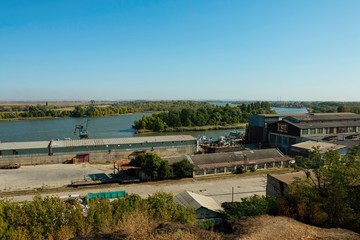 Water area of the Don river and industrial port with crane, established in coastal street in Azov.