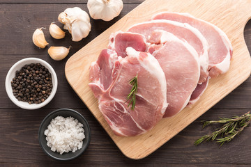 Top view raw fresh meat and salt, pepper, garlic on wooden backg