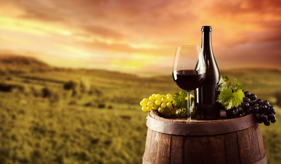 Fototapety  Butelka czerwonego wina i kieliszek na drewnianej beczce