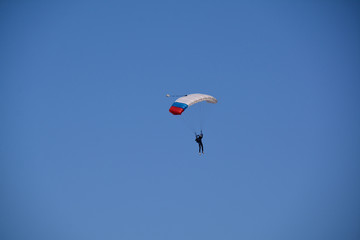 small parachutist high in the sky