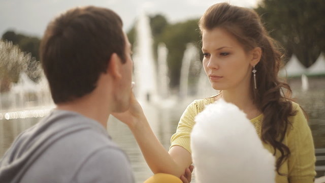 loving couple feeding each other cotton candy at the park