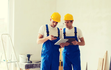 builders with tablet pc and equipment indoors