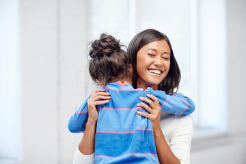 happy mother and daughter hugging at home