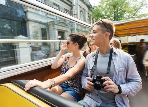 smiling couple with camera traveling by tour bus