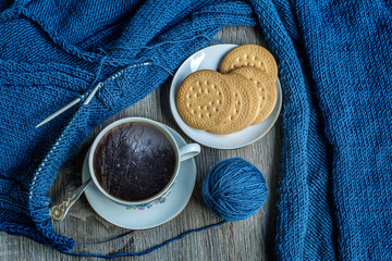 Double exposure still life with coffee, knitting and winter landscape