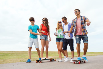 Obraz premium happy teenage friends with longboards outdoors
