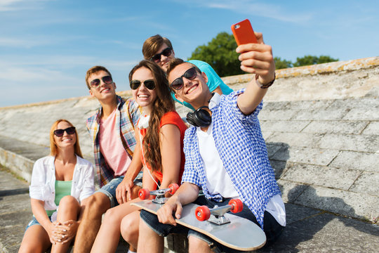happy friends with smartphone taking selfie
