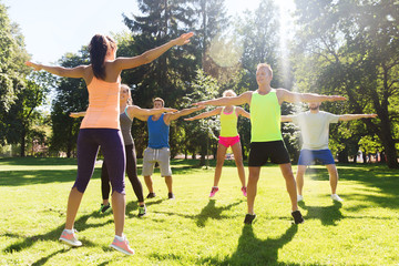 group of happy friends exercising outdoors